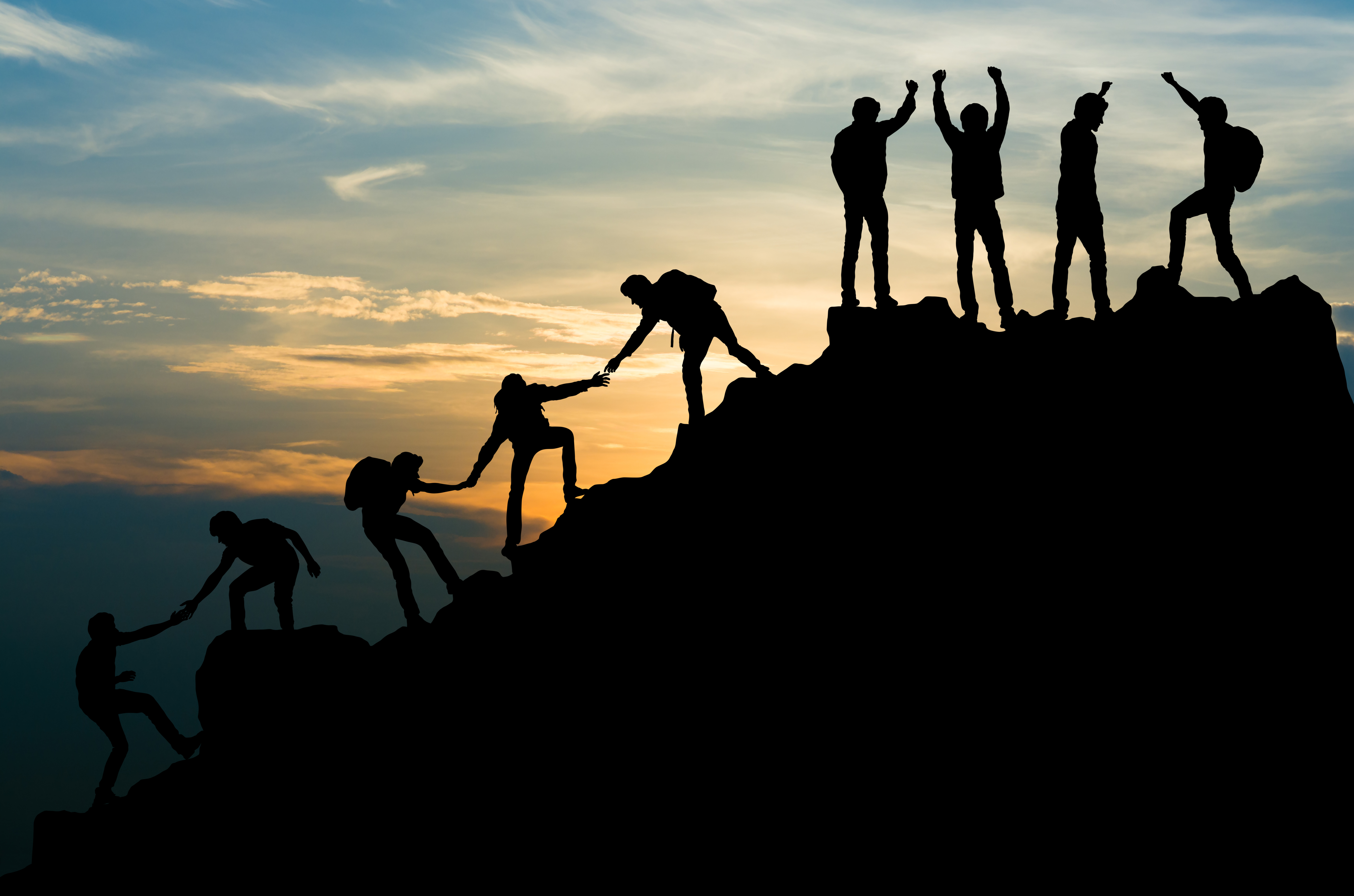 Team helping each other reach the summit